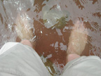 Bare feet standing in red sand.